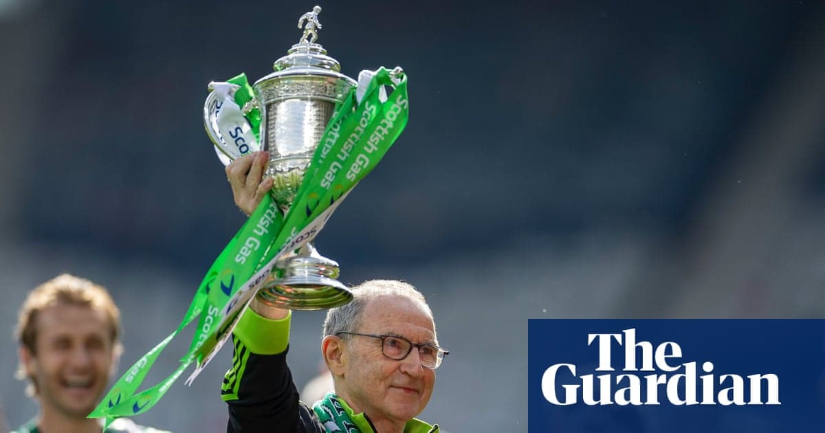 Manager holding trophy with green ribbons after victory