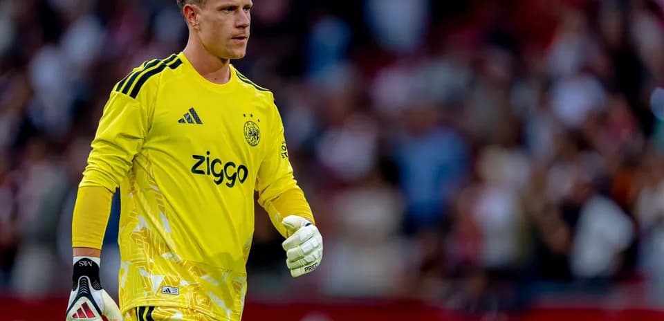 Goalkeeper in yellow kit walking on the pitch