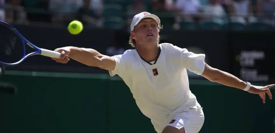 Tennis player reaching for a ball during match