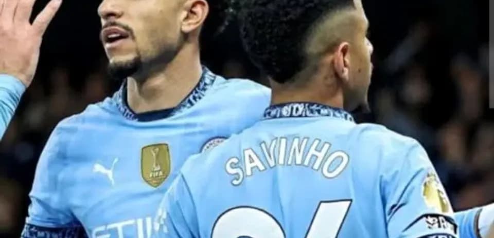 Two Manchester City players celebrating on the pitch