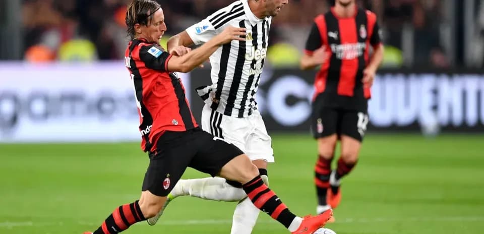 Player from AC Milan tackling Juventus player on field