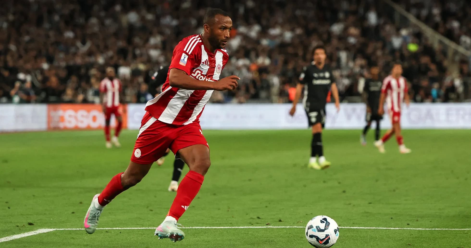 Player in red and white kit running with ball