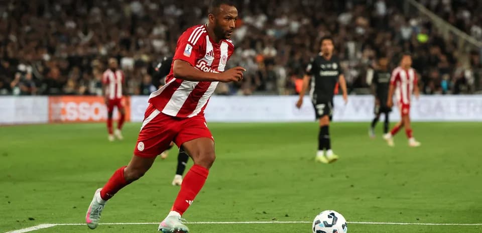 Player in red and white kit running with ball