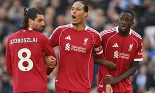 Three Liverpool players discussing during a match
