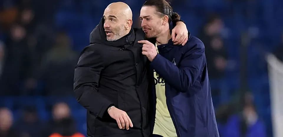 Two men embracing on football pitch after match