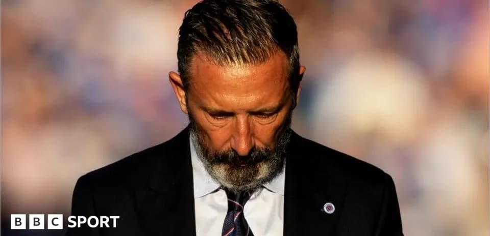 Man in suit with head down, focused expression