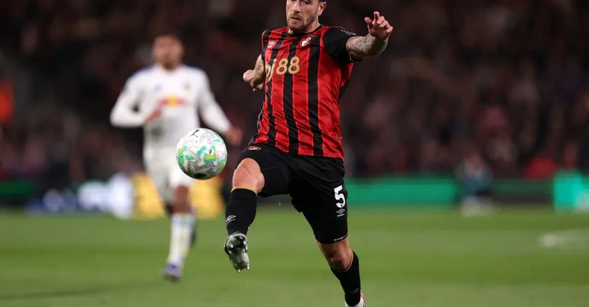 Player kicking ball during match with opposing player in background