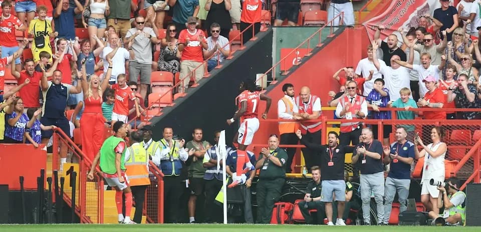 Player celebrating with fans at stadium after goal