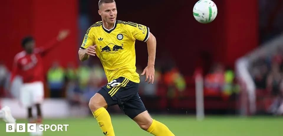 Player in yellow kit chasing a ball during match