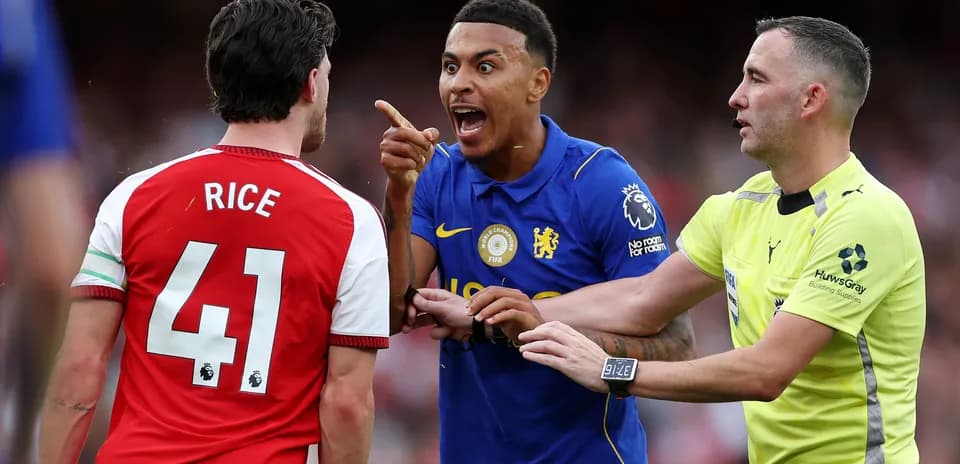Players arguing during a match, referee intervening