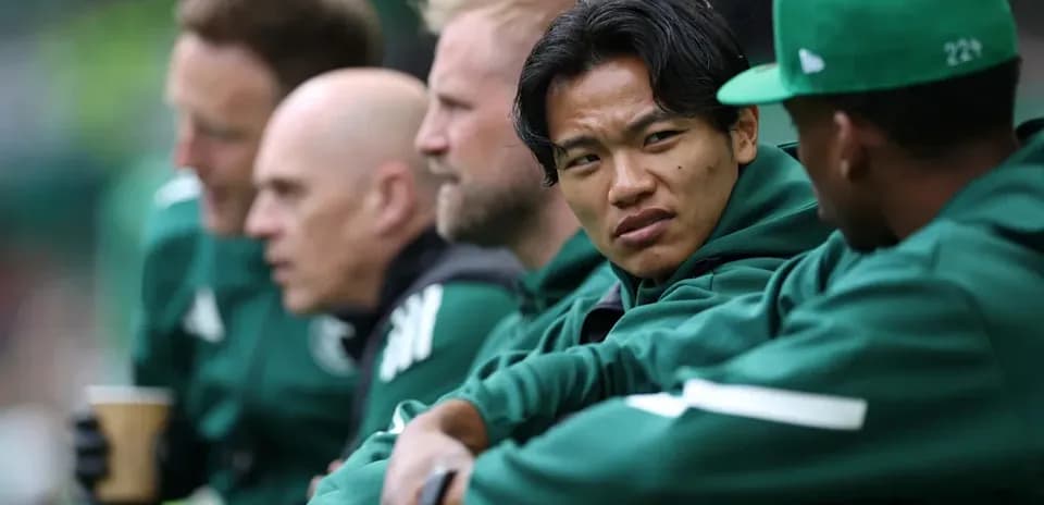 Coaches and players seated on the bench during match