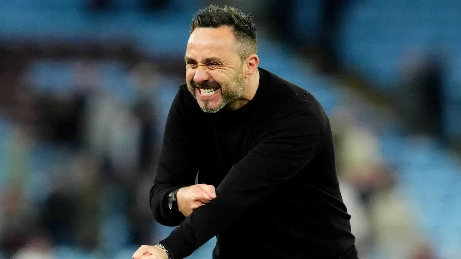Coach celebrating during a match on the sidelines