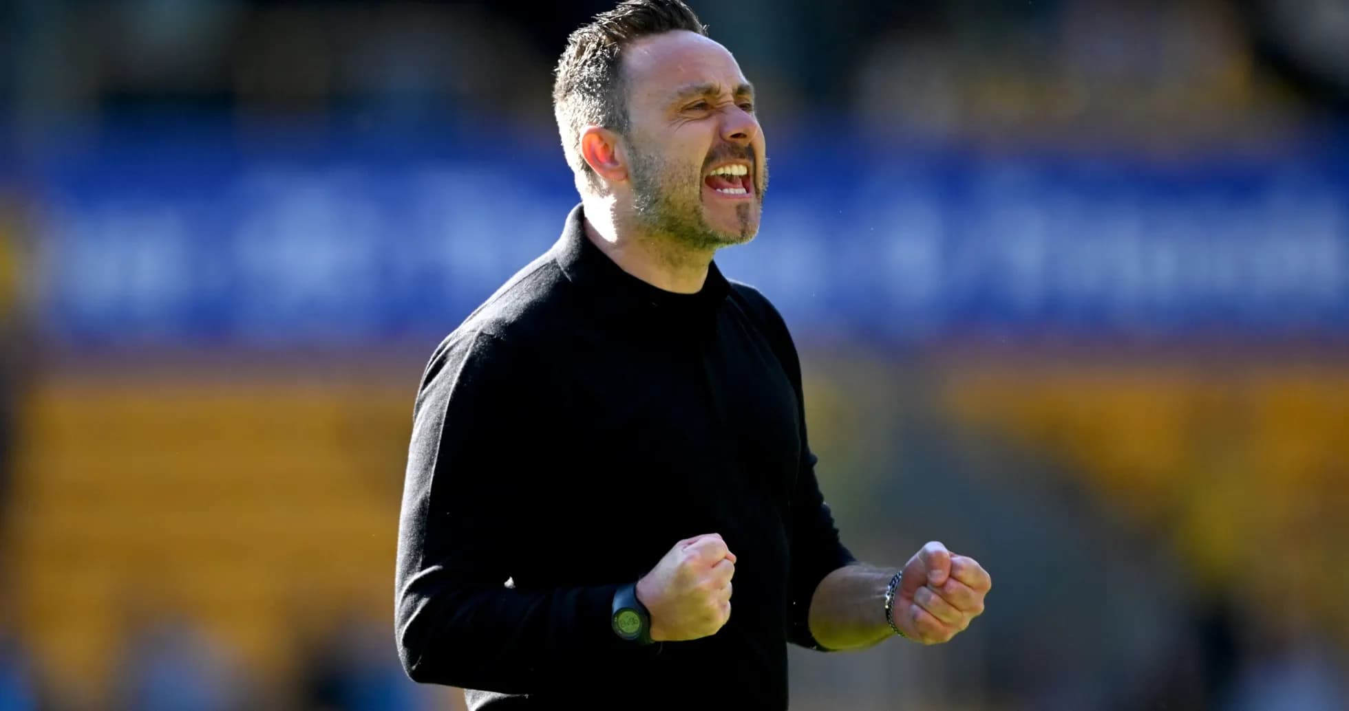Manager celebrating with clenched fists on sidelines