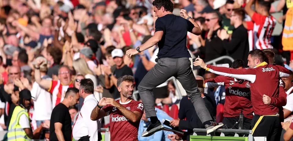 Coach celebrating with fans after a goal