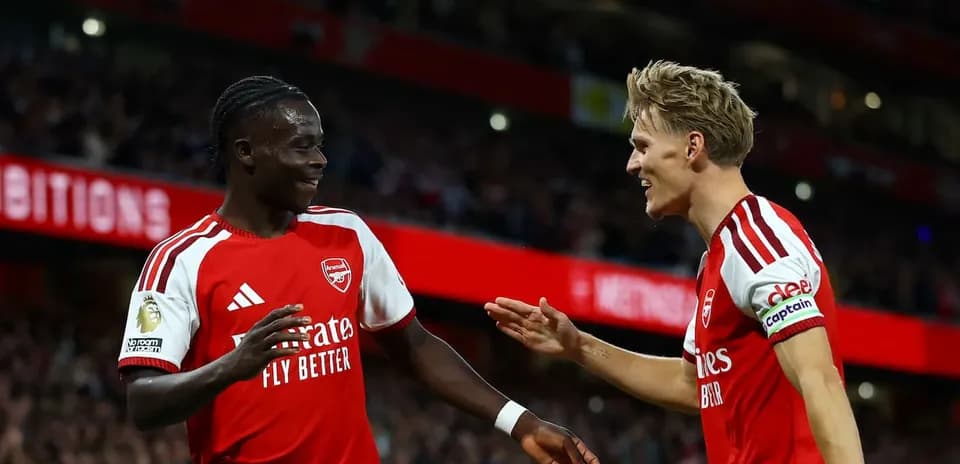 Two Arsenal players celebrating a goal together