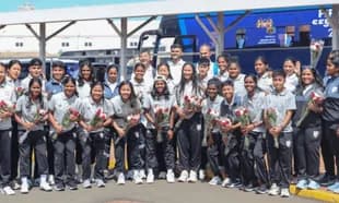 Women's sports team posing with roses at arrival