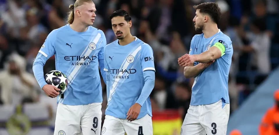 Three Manchester City players discussing during a match