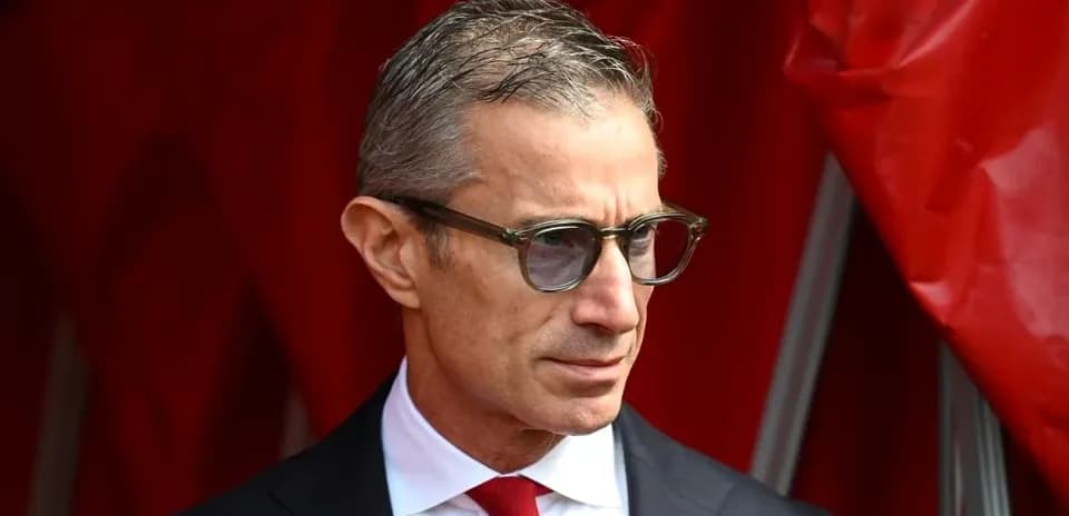 Man in glasses standing near red backdrop