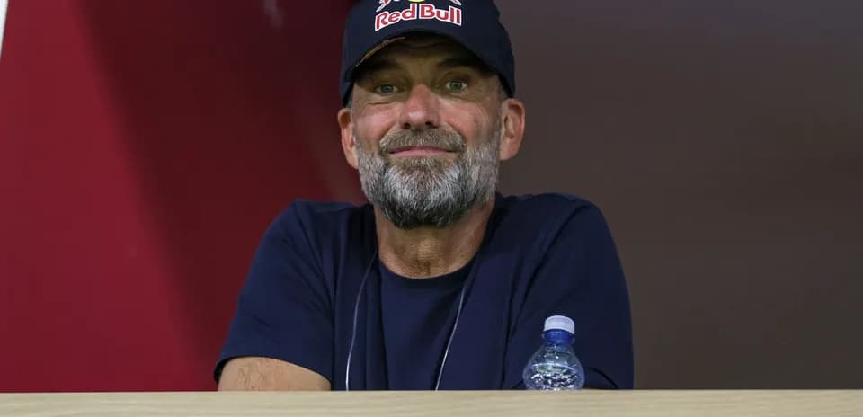 Man with beard wearing Red Bull cap watching event