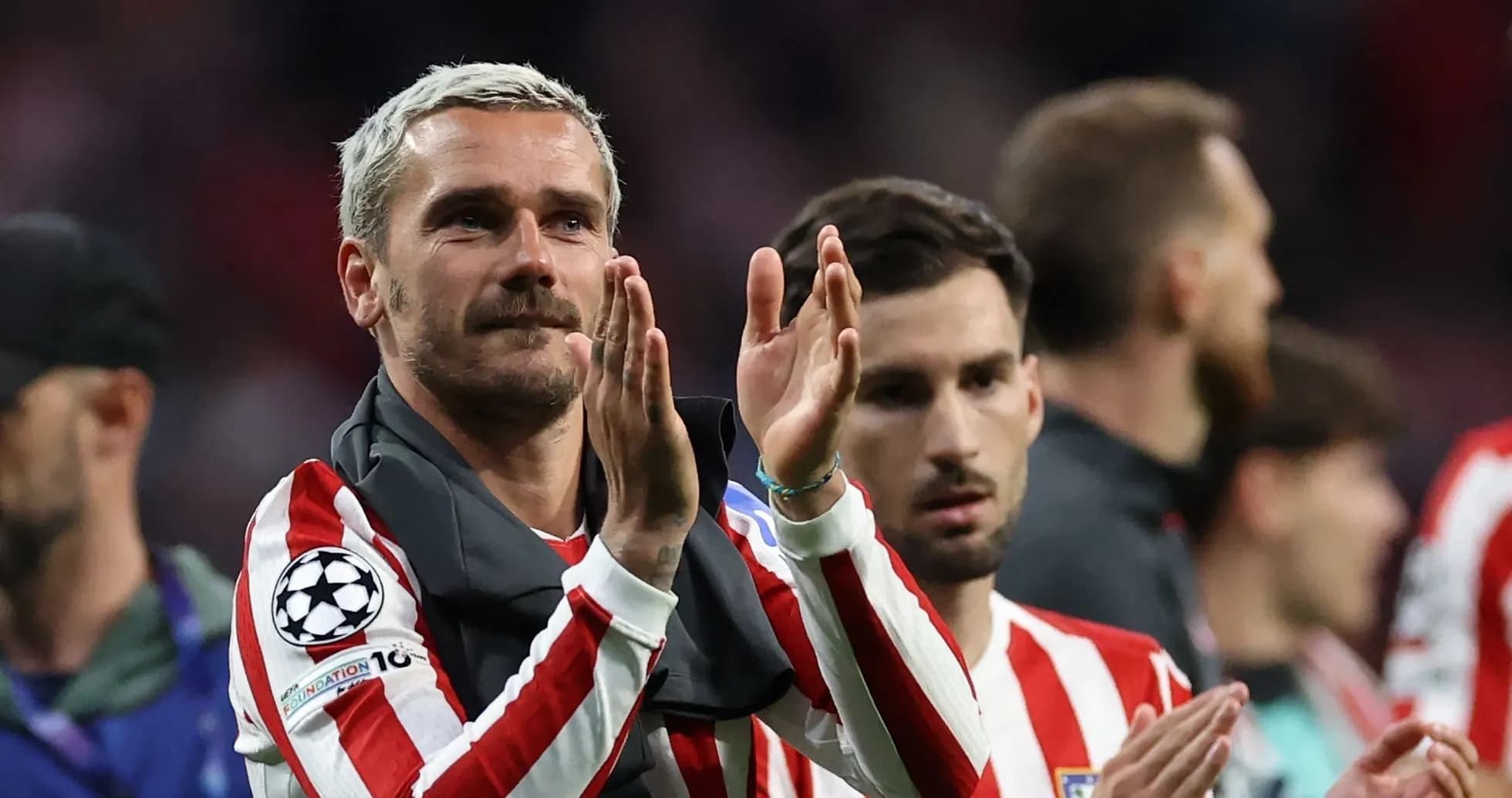 Player applauding fans after match with teammates