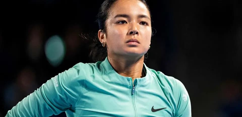 Tennis player in a teal jacket during match