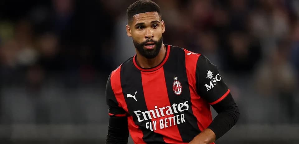 AC Milan player in black and red jersey on field
