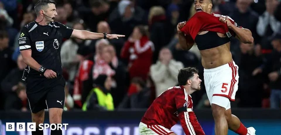 Player celebrating while referee signals during match