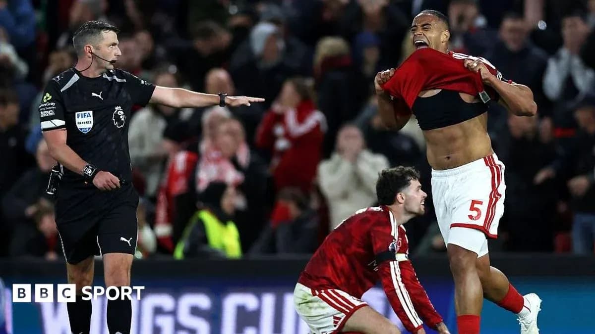 Player celebrating while referee signals during match