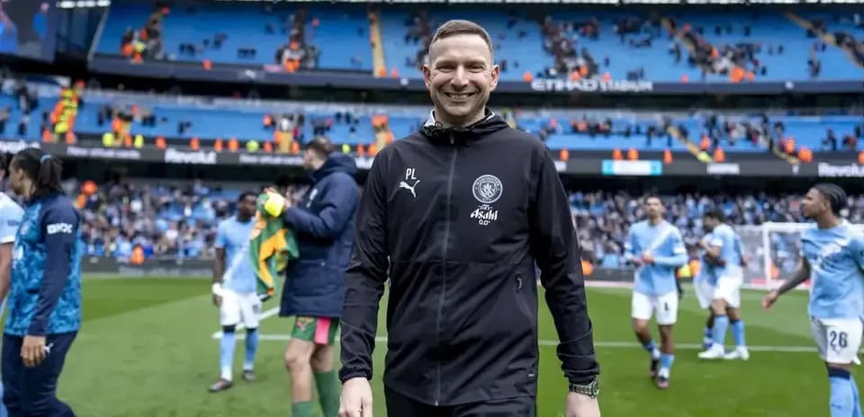 Coach smiling after match at Etihad Stadium