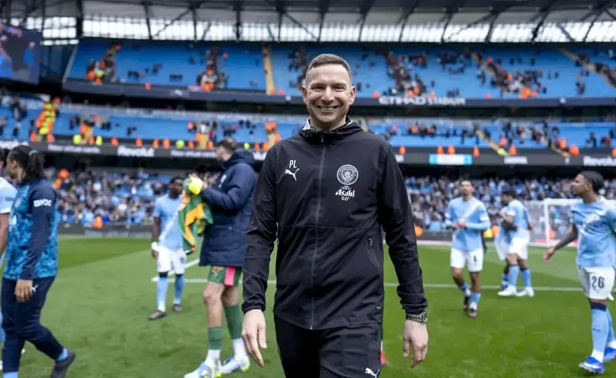 Coach smiling after match at Etihad Stadium