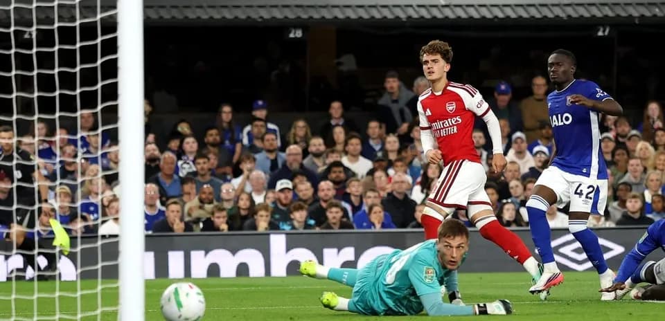 Arsenal player celebrates after scoring against goalkeeper