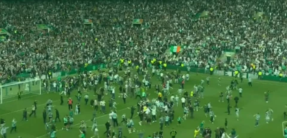 Fans celebrating on the pitch after match
