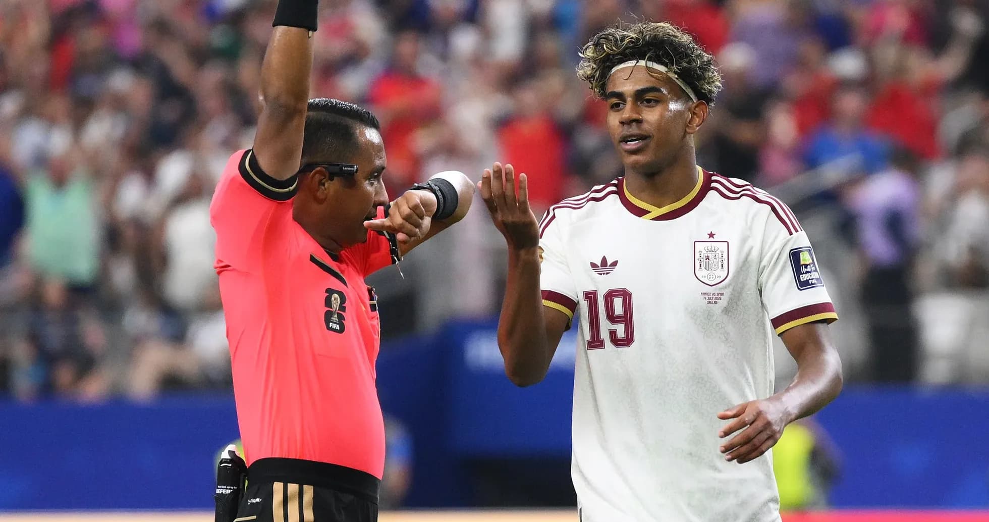 Referee issuing a card to Spanish player during match
