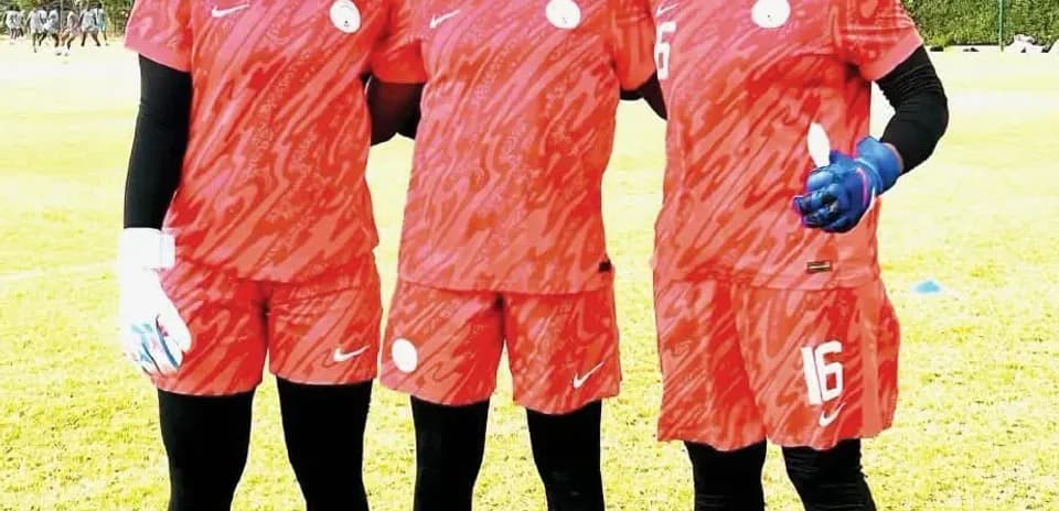 Three female soccer players posing in training kits