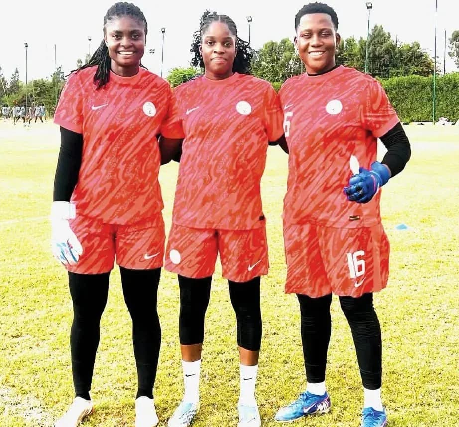 Three female soccer players posing in training kits