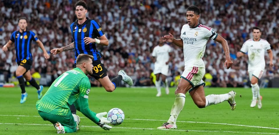 Real Madrid player chasing the ball past goalkeeper