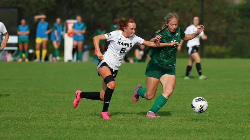 Two players competing for the ball on field
