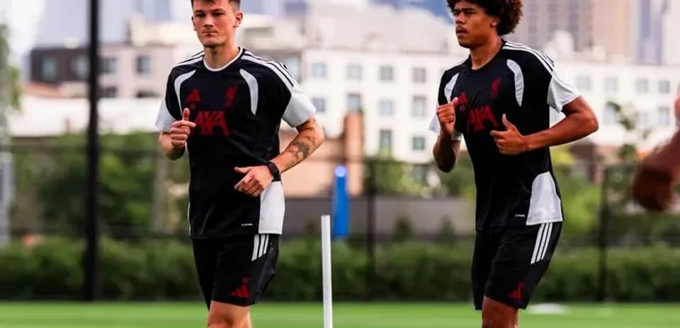 Two players jogging during training session on pitch