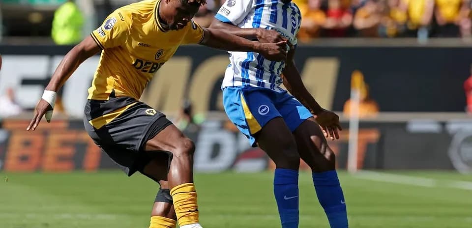 Brighton player challenging Wolves opponent for the ball
