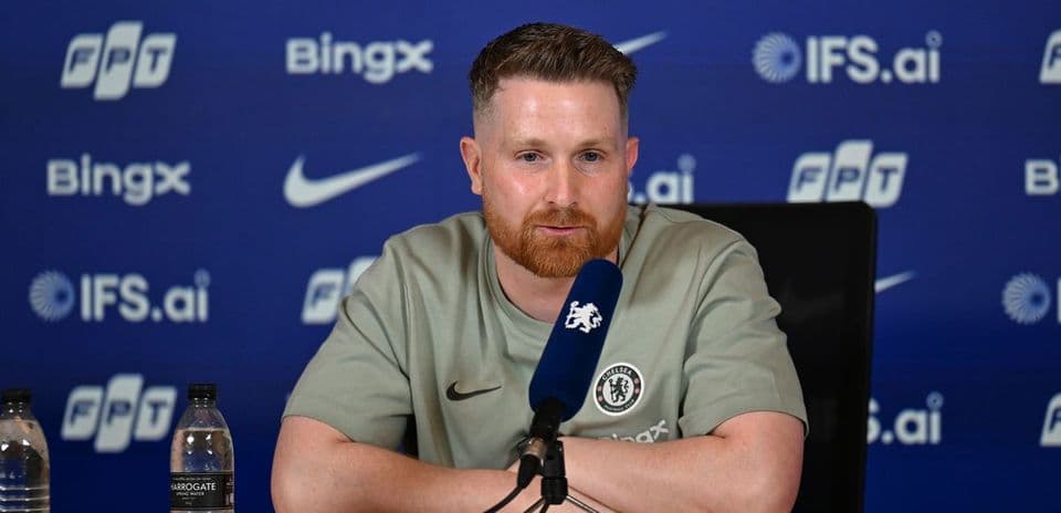 Manager speaking at press conference with logos