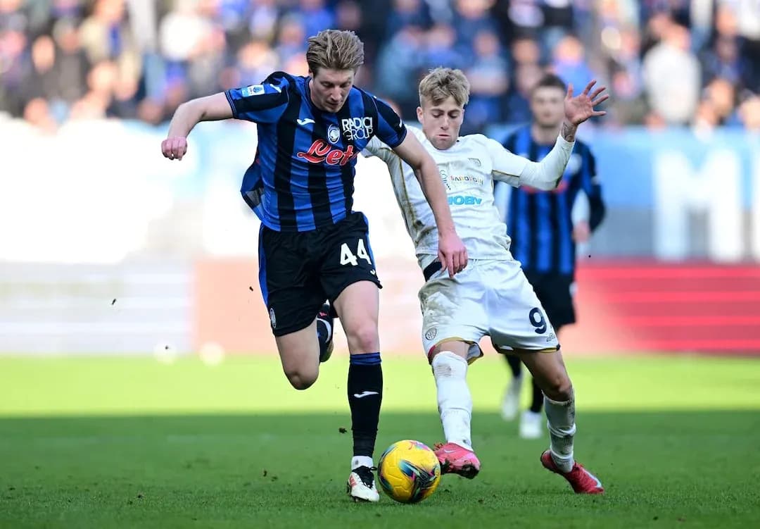 Cagliari player challenges Atalanta opponent for the ball