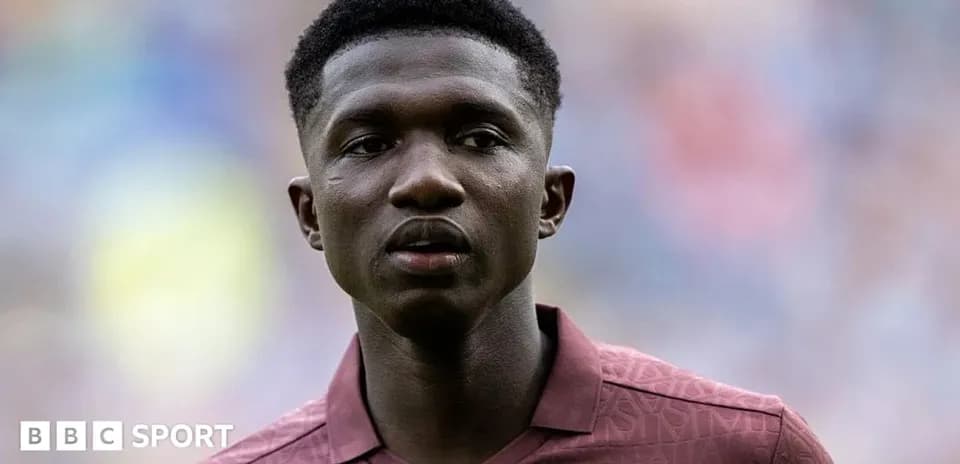 Player in maroon kit during match warm-up