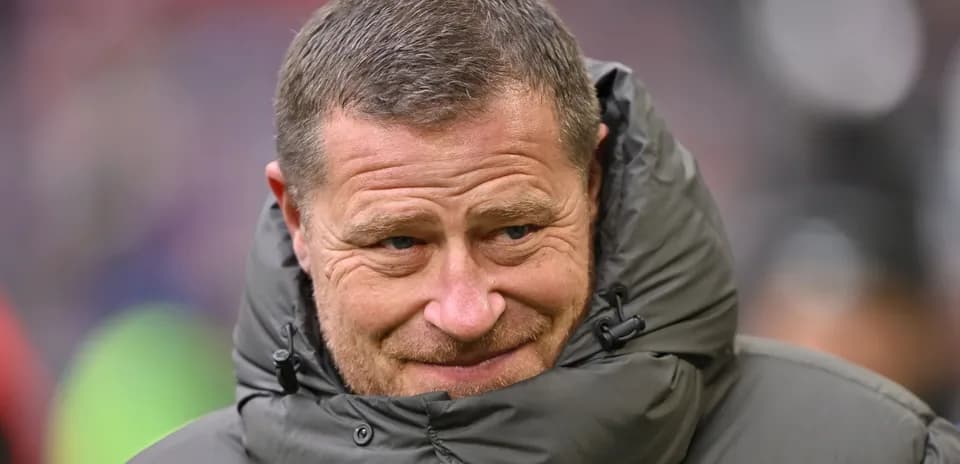 Coach wearing a padded jacket during match