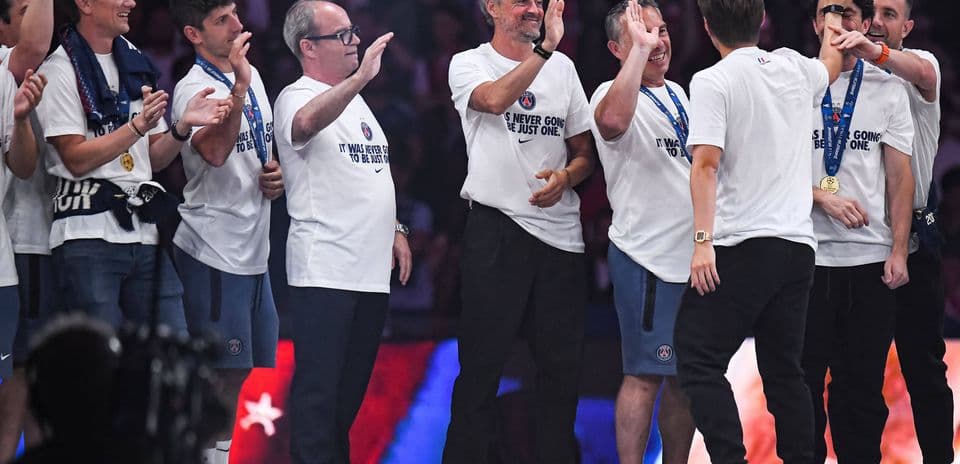 Team celebrating with medals and T-shirts on stage
