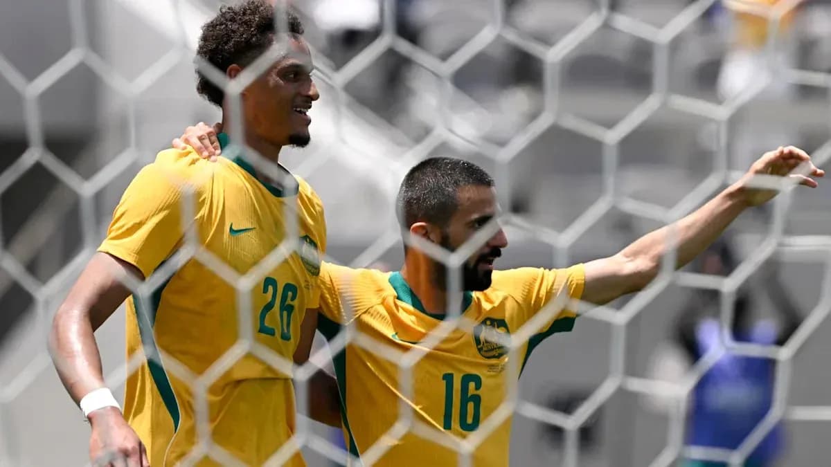 Two Australian players celebrating a goal on field