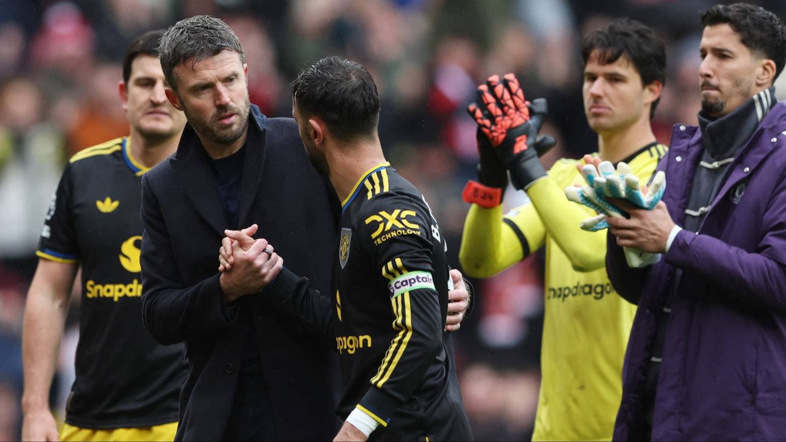 Manager and player shaking hands on the pitch