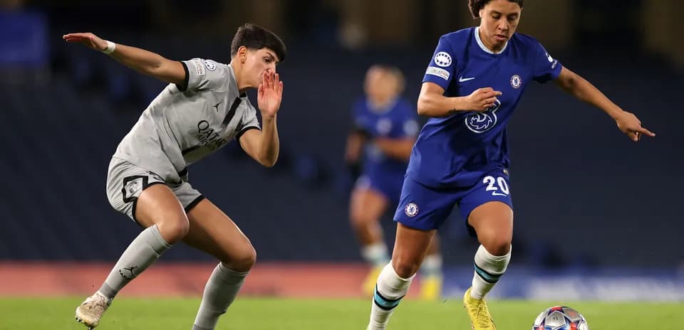 Chelsea player dribbling past PSG opponent