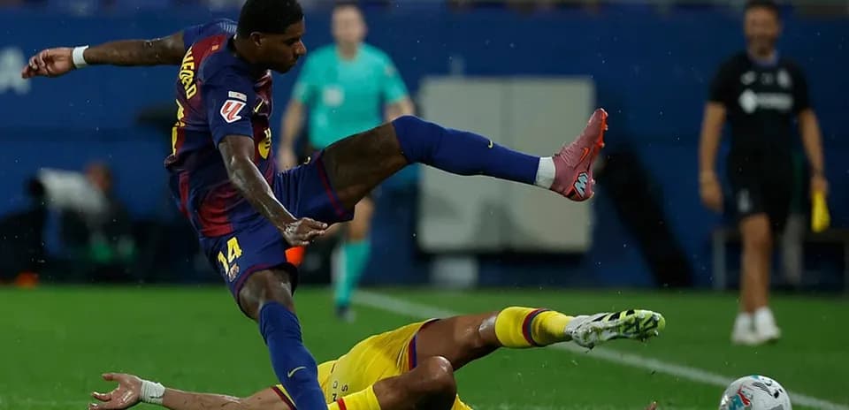 Barcelona player tackling Getafe player during match
