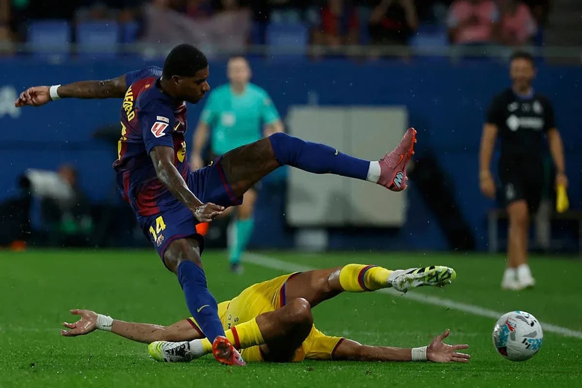 Barcelona player tackling Getafe player during match