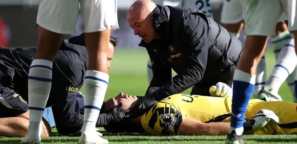 Medical staff attending to injured goalkeeper on field